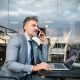 Mature businessman with smartphone in an outdoor hotel cafe.